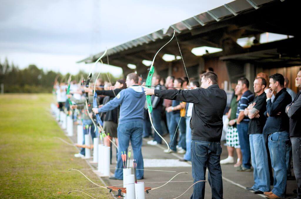 A group of people drawing archery bows